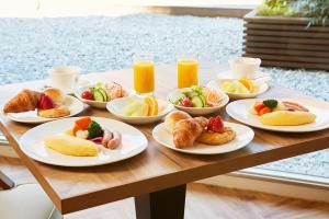 a table with plates of breakfast foods and orange juice at Tokyo Prince Hotel in Tokyo