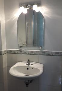 uma casa de banho com um lavatório branco e um espelho. em Khách Sạn Ngọc Hân em Ấp Vĩnh Phú