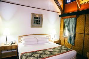 a bedroom with a large bed and a large window at Mutiara Taman Negara Resort in Kuala Tahan