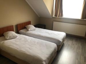 - 2 lits dans une chambre d'hôtel avec fenêtre dans l'établissement Prestige Flats Coteaux, à Bruxelles