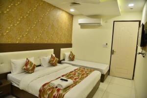 a hotel room with two beds and a door at Hotel Oscar in Amritsar +46 photos