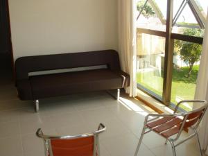 Un banco negro en una habitación con ventana. en Jurerê - Canto Belo, en Florianópolis