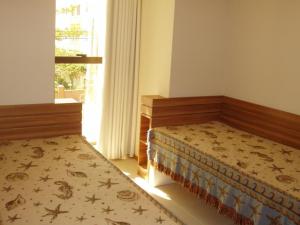 Un dormitorio con dos camas y una ventana. en Jurerê - Canto Belo, en Florianópolis