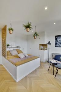 een slaapkamer met een groot bed met potplanten aan de muur bij L’Alcôve Royale in Versailles