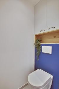 ベルサイユにあるL’Alcôve Royaleの青い壁のバスルーム(白いトイレ付)