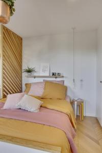 a bedroom with a bed with yellow and pink sheets at L’Alcôve Royale in Versailles