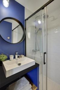 a bathroom with a white sink and a mirror at L’Alcôve Royale in Versailles