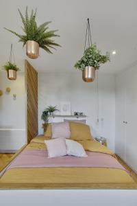 a large bed in a bedroom with two potted plants at L’Alcôve Royale in Versailles