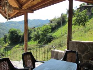 a table and chairs on a porch with a view at Zinca's Cottage in Ogled