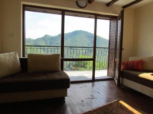 a living room with a couch and a large sliding glass door at Zinca's Cottage in Ogled +2 photos