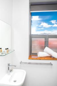 uma casa de banho com lavatório e uma janela com toalhas em Zeederberg Corner em Paarl