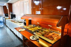 um buffet com comida num quarto de hotel em Hotel Emma Est em Craiova mais 25 fotografias