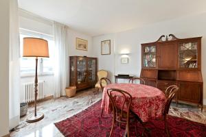 a dining room with a table and chairs and a lamp at Condominio Torcello Vintage Apartment in Mestre