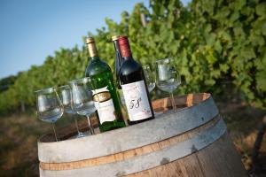 three bottles of wine in a barrel with wine glasses at Weinschlößchen im Weingut Roos in Ilbesheim