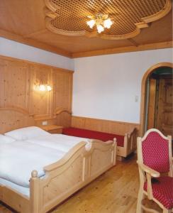 een slaapkamer met een groot bed en 2 stoelen bij Kasparbauer in Sankt Michael im Lungau