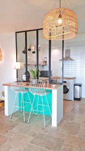 a kitchen with a blue table and two chairs at LA BOHEME, résidence de 5 appartements avec piscine, vue océan, Petite Ile in Petite Île