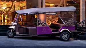 Amaranta Hotel - SHA Plus في بانكوك: سيارة قولف أرجوانية متوقفة أمام مبنى