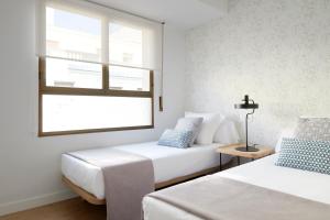 1 dormitorio con 2 camas y ventana en San Francisco 2 by FeelFree Rentals, en San Sebastián