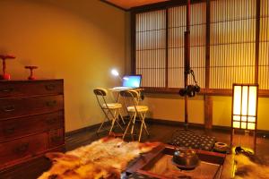 a living room with a table and a laptop on a desk at Hida Takayama Hodakaso Yamano Iori in Takayama