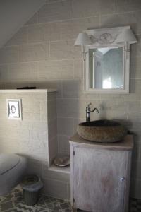 y baño con lavabo y espejo. en Le Manoir des Arômes, en Brugny-Vaudancourt