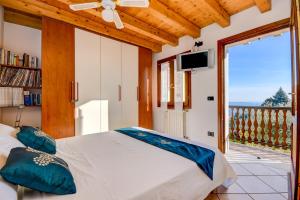 ein Schlafzimmer mit einem Bett und einem großen Fenster in der Unterkunft Appartamento Lago Blu in Gardone Riviera