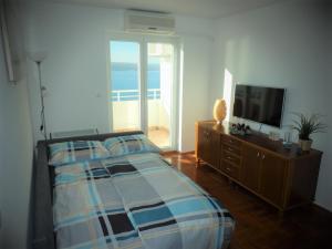 a bedroom with a bed and a flat screen tv at Aspectus Apartment in Crikvenica