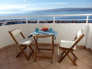 a table with a bowl of fruit on a balcony at Aspectus Apartment in Crikvenica