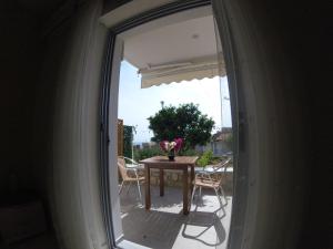 una puerta de cristal que da a un patio con mesa y sillas en Riviera Rooms, en Himare