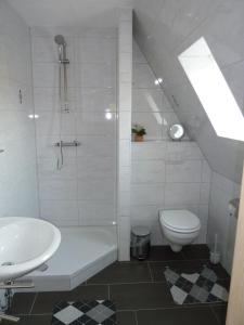 a white bathroom with a sink and a toilet at Bernstein in Zingst