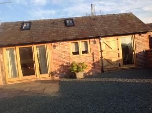 a brick house with a door and windows at ANVIL COTTAGE in Whitchurch