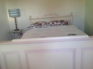 un lit blanc avec une tête de lit blanche dans une chambre dans l'établissement ANVIL COTTAGE, à Whitchurch