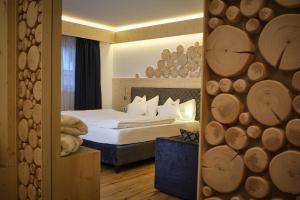 a hotel room with a bed and a mirror at Cimon Dolomites Hotel in Predazzo