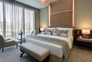 a hotel room with two beds and a large window at Grand Millennium Business Bay in Dubai