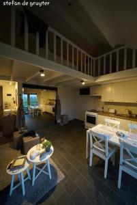 a kitchen with tables and chairs in a room at B&B 't Hoveke in Wingene