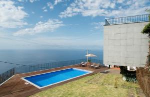 a swimming pool on the side of a house at Casa da Manta in Fajã da Ovelha