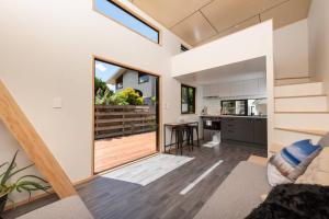 a kitchen and living room with a large sliding glass door at Cozy Tiny House Hideaway in Tauranga