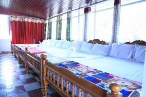 een groot bed in een kamer met ramen bij White Clouds Cottage Munnar in Munnar