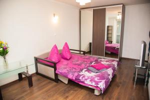 a bedroom with a bed with pink sheets and pillows at Semi-luxury Apt on Ukrainskaya 43 Street in Zaporozhye