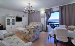 a living room with white furniture and a view of the ocean at Apartment Lea in Senj