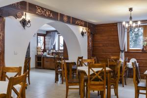 a restaurant with wooden walls and tables and chairs at Chata u Bronka in Białka Tatrzańska