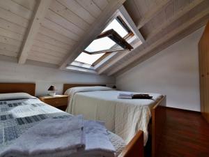 a attic room with two beds and a skylight at Palmaria in Deiva Marina