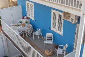 un balcone con tavolo, sedie e parete blu di Mareinsicilia Cannamara Appartamenti a Donnalucata