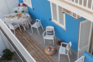 a balcony with a table and chairs and a blue wall at Mareinsicilia Cannamara Appartamenti in Donnalucata