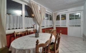 a dining room with a table and chairs and windows at Apartment Lea in Senj +35 photos