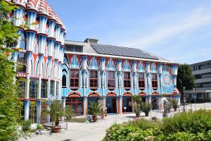 - un grand bâtiment bleu et rouge dans l'établissement Hotel Fuchspalast, à Sankt Veit an der Glan