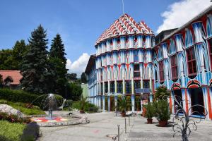 un grand bâtiment avec un toit rouge et bleu dans l'établissement Hotel Fuchspalast, à Sankt Veit an der Glan