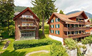 a house with flower boxes on the balconies of it at Hirschen Guesthouse - Village Hotel in Wildhaus