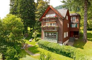 una casa con un balcón con flores. en Hirschen Guesthouse - Village Hotel, en Wildhaus