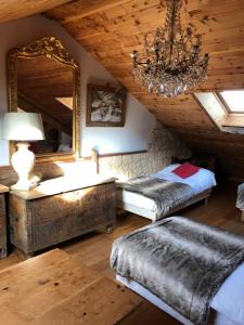 1 dormitorio con 2 camas, espejo y lámpara de araña en Hôtel Restaurant de la Chaussée en Briançon