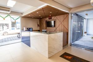 a kitchen with a counter with a tv and a counter at Panorama Convention Hotel in Coronel Fabriciano